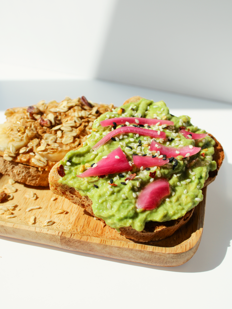 bamboo plate with avocado toast and banana nut toast against a white backdrop