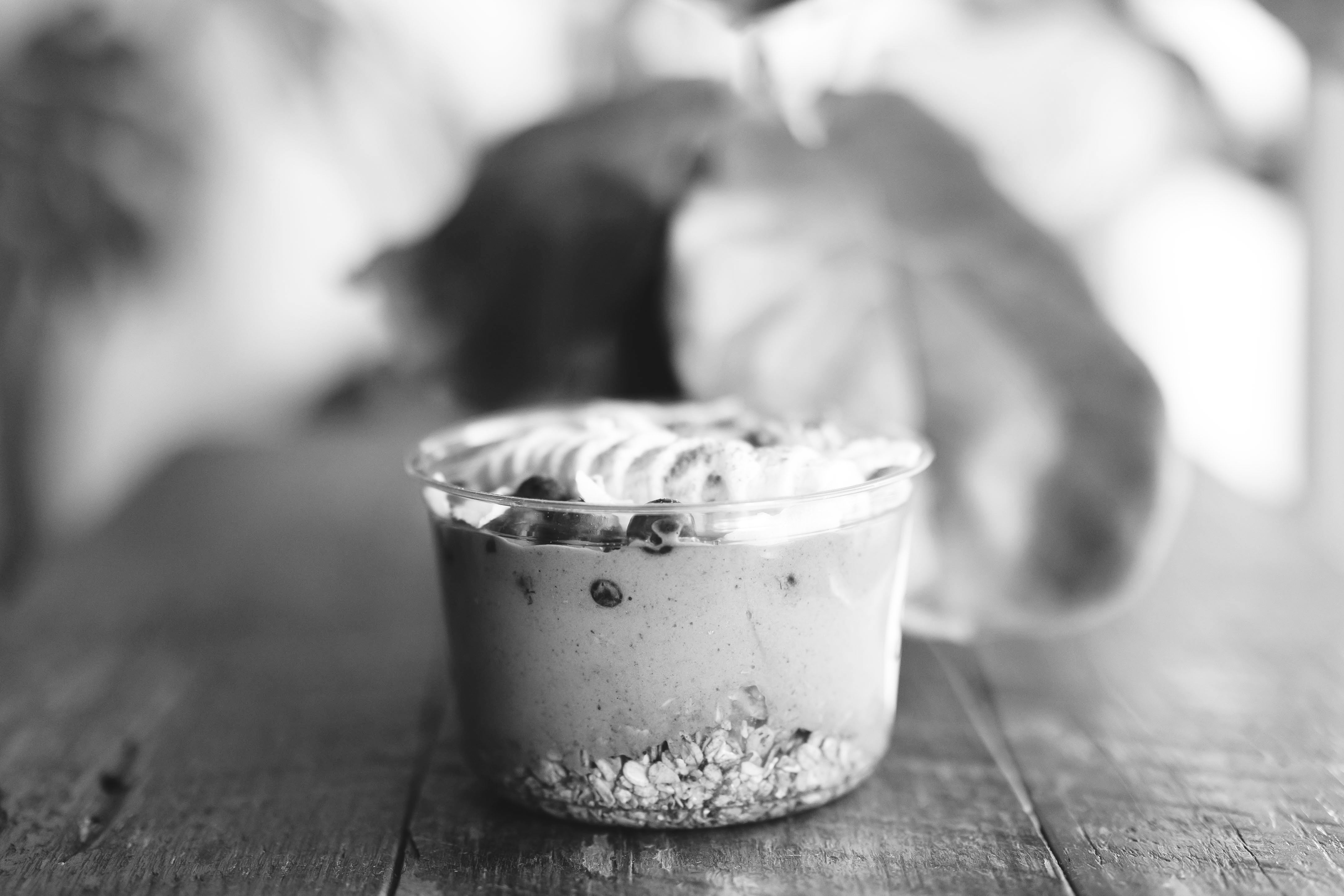 smoothie bowl on a wooden table with bananas and granola