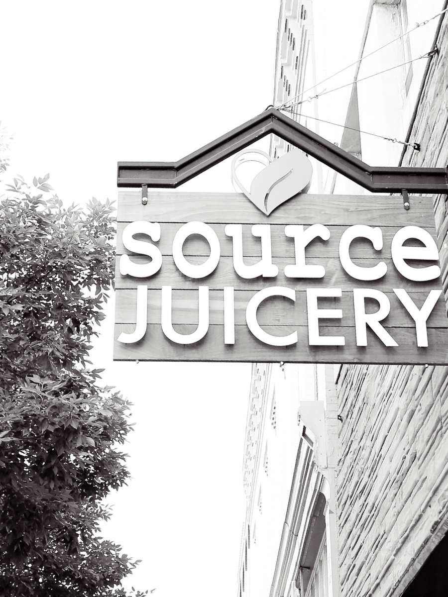 black and white sign hanging on the exterior of a building reading