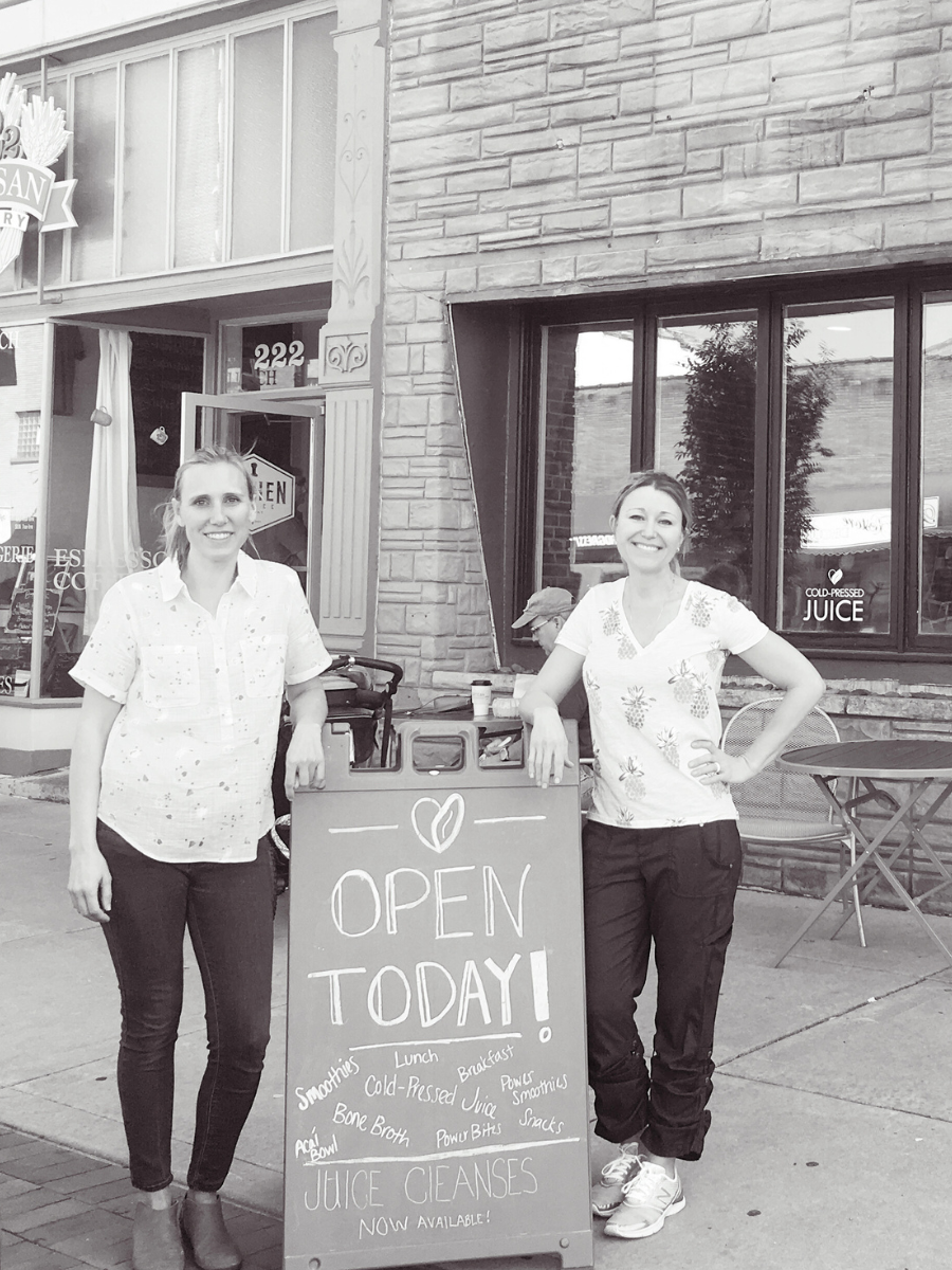 two women standing outside a stone building with an