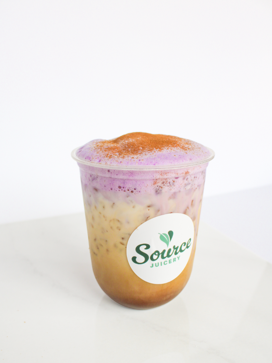 ube latte with purple cold foam and cinnamon dusted on top against a white backdrop